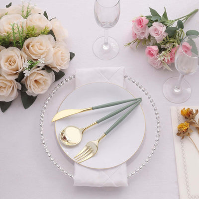Elegant dining setup with gold-accented cutlery and floral centerpiece.