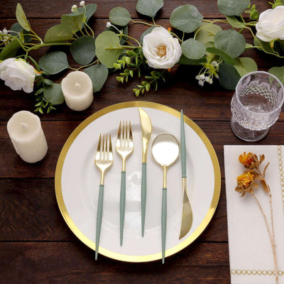 Elegant table setting with gold-accented cutlery, floral decor, and candles.