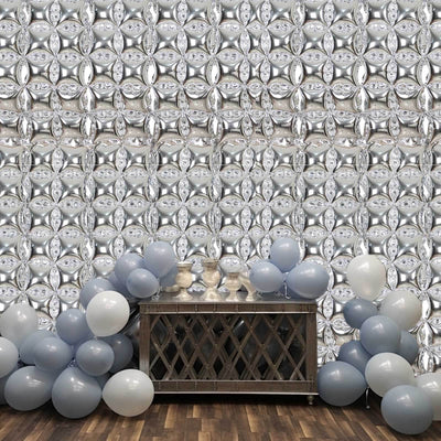 Decorative silver balloon backdrop with gray balloons and a wooden table.