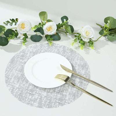Elegant gray patterned placemat with white plate and gold cutlery.