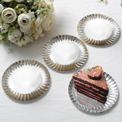 Chocolate cake slice on silver dessert plate with floral arrangement in background.