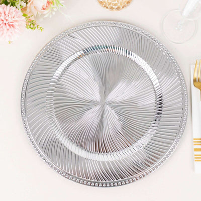 Silver decorative charger plate with a ridged pattern.