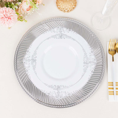 Elegant silver-trimmed dinner plate with ornate design on a table setting.