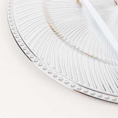 Silver decorative plate with intricate patterns and dotted edges.