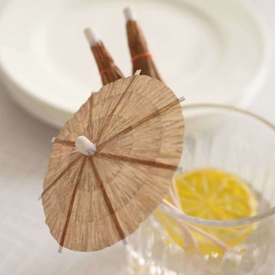 Mini cocktail umbrella on a glass with lemon slice.