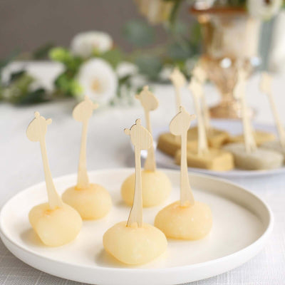 Delicious fruit-shaped desserts on a white plate with decorative sticks.