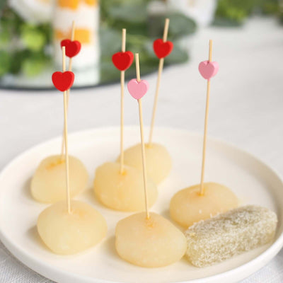 Heart-topped dessert bites on a plate, perfect for celebrations.