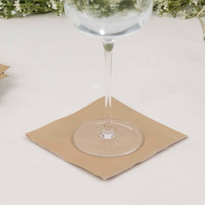 Glass on a beige coasters with floral decor in the background.