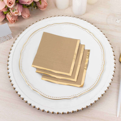 Gold-trimmed beige napkins stacked on an elegant plate.