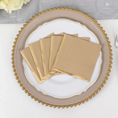 Gold-bordered disposable napkins arranged on a decorative plate.