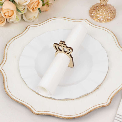 Elegant crown napkin holder on a decorative plate with floral accents.