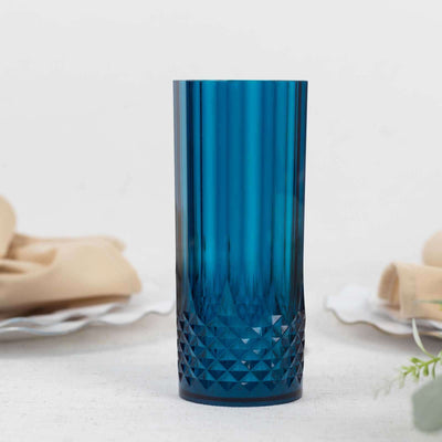 Blue textured glass tumbler on a white backdrop.