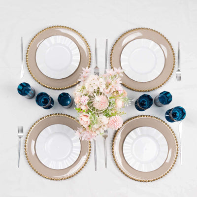 Elegant dinner table setting with plates, glasses, and floral centerpiece.