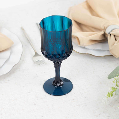 Blue crystal goblet on a table setting with napkin and plates.