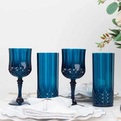 Set of four elegant blue glassware pieces on a white table setting.