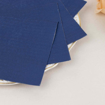 Navy blue textured cardstock sheets on a decorative plate.