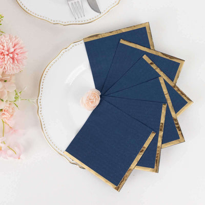 Navy blue place cards with gold edges on an elegant plate setting