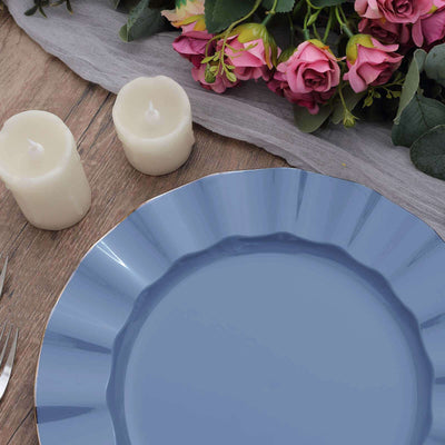 Elegant blue plate on a rustic table with candles and flowers.