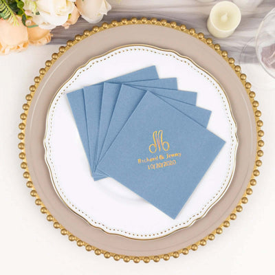 Personalized blue napkins with gold monogram for wedding reception decor.
