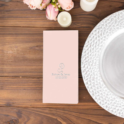 Elegant pink wedding invitation with embossed text on wooden table.