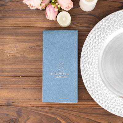 Elegant wedding menu in blue with gold embossing on wooden table.