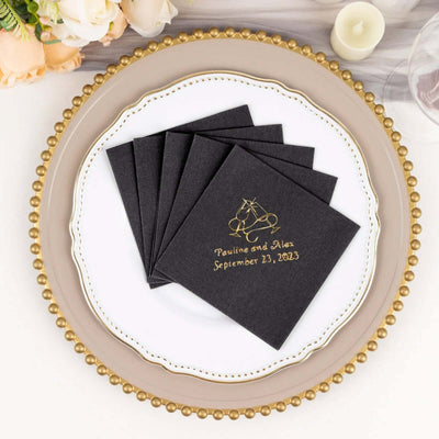 Elegant black wedding invitations with gold lettering on a decorative plate.