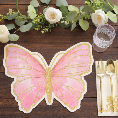 Pink butterfly-shaped table placemat with gold accents on a wooden table setting.