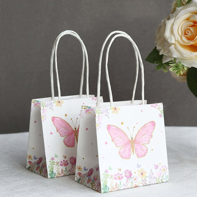 Floral butterfly gift bags with handles in a studio-style shot.