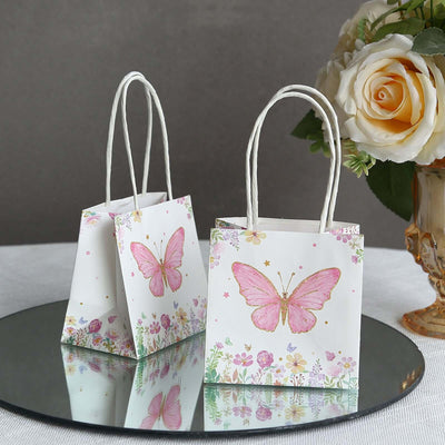 Decorative gift bags with butterfly design and floral accents on a mirrored surface.