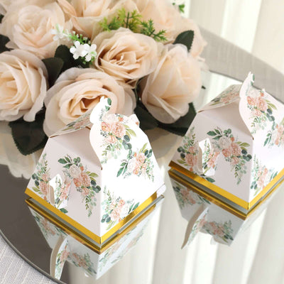 Floral-themed gift boxes on a reflective surface with roses in the background.