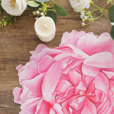 Pink peony flower illustration with greenery and a white candle on a wooden surface.