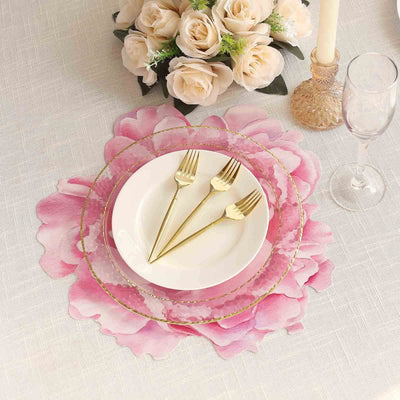 Elegant gold cutlery on a pink floral placemat with a white plate.