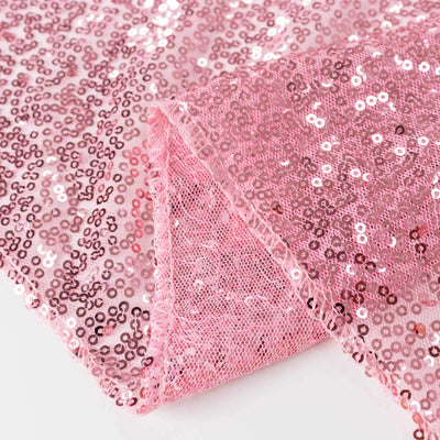 Pink sequin fabric with a mesh backing, perfect for crafting and special events.