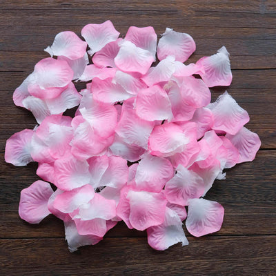 Pink and white rose petals arranged on a wooden surface.