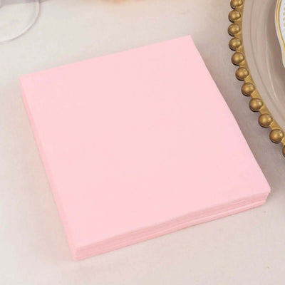 Pink paper napkins stacked neatly on a table.