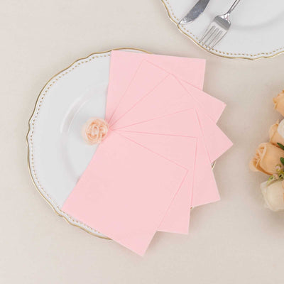 Pink stationery set on a white plate with a rose on the side.