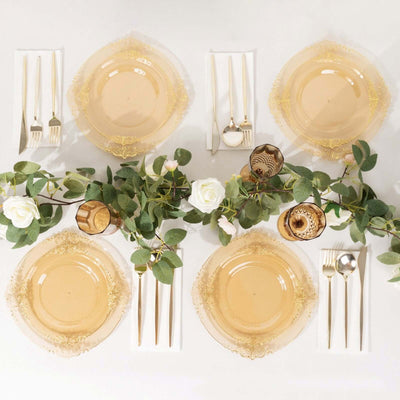 Elegant gold-trimmed dinnerware set with greenery and floral accents.