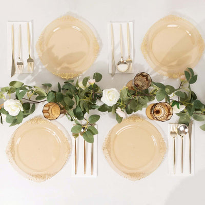 Elegant dinner table setting with beige plates, cutlery, and greenery.