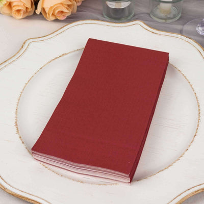 Red napkins stacked on a decorative plate for table setting.