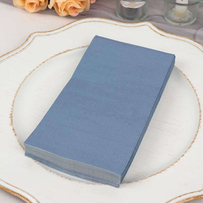 Stack of blue paper napkins on a decorative plate.