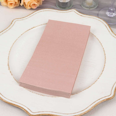 Pink napkins stacked on a decorative plate for elegant table setting.