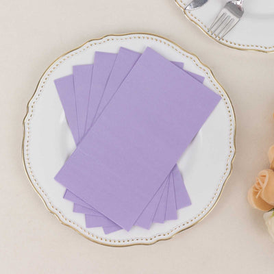 Purple napkins neatly arranged on a decorative plate.