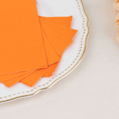 Orange paper sheets neatly arranged on a decorative plate.