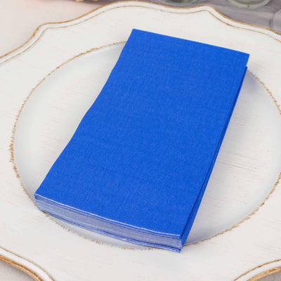 Stack of blue paper napkins on a decorative plate.