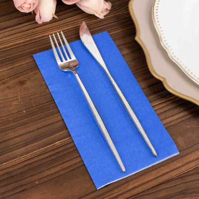Silver fork and knife on a blue napkin with wooden table background.