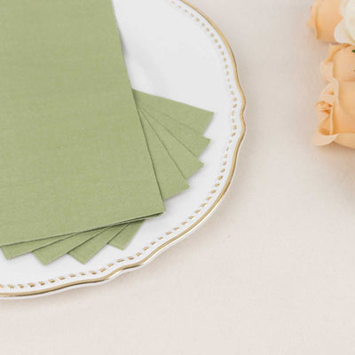 Green textured paper sheets on a decorative plate with soft-colored roses.