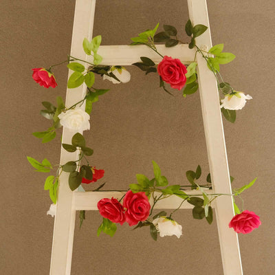 Artificial rose garland on a white wooden ladder