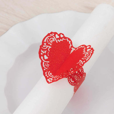 Red lace heart napkin ring on a white plate.
