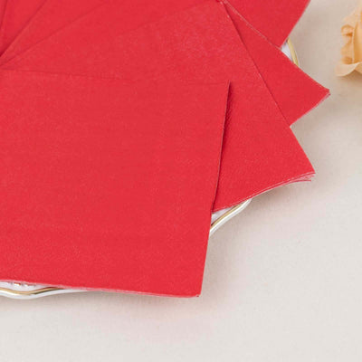 Red napkins arranged on a decorative plate.
