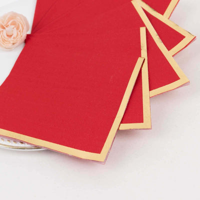 Red napkins with gold trim on a white plate
